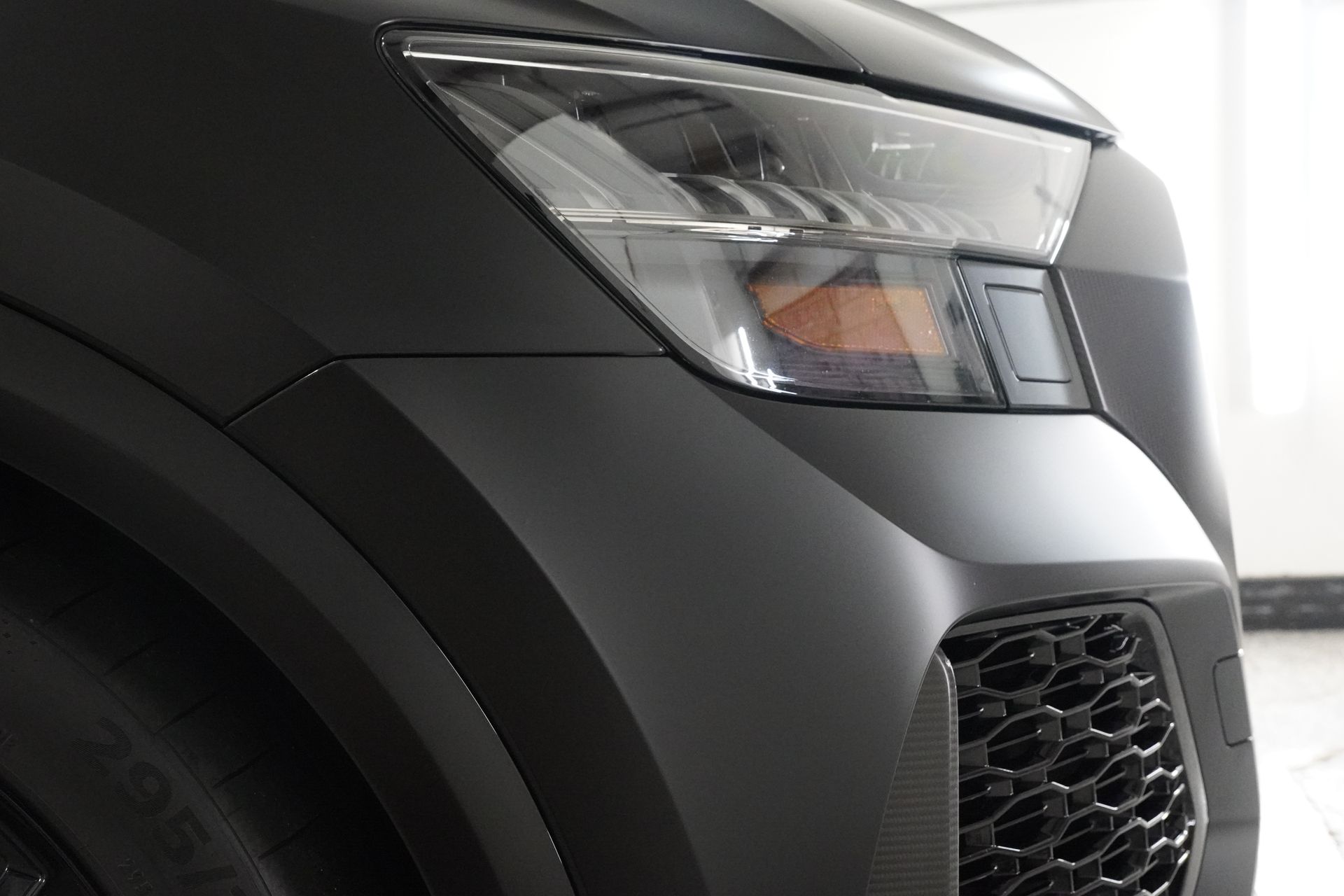 A close up of the headlight of a black car