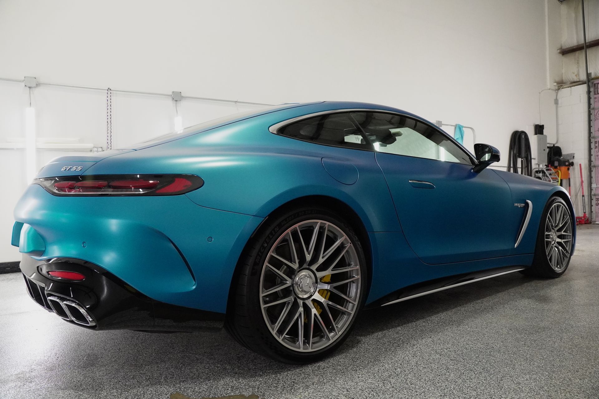 A blue sports car is parked in a garage.