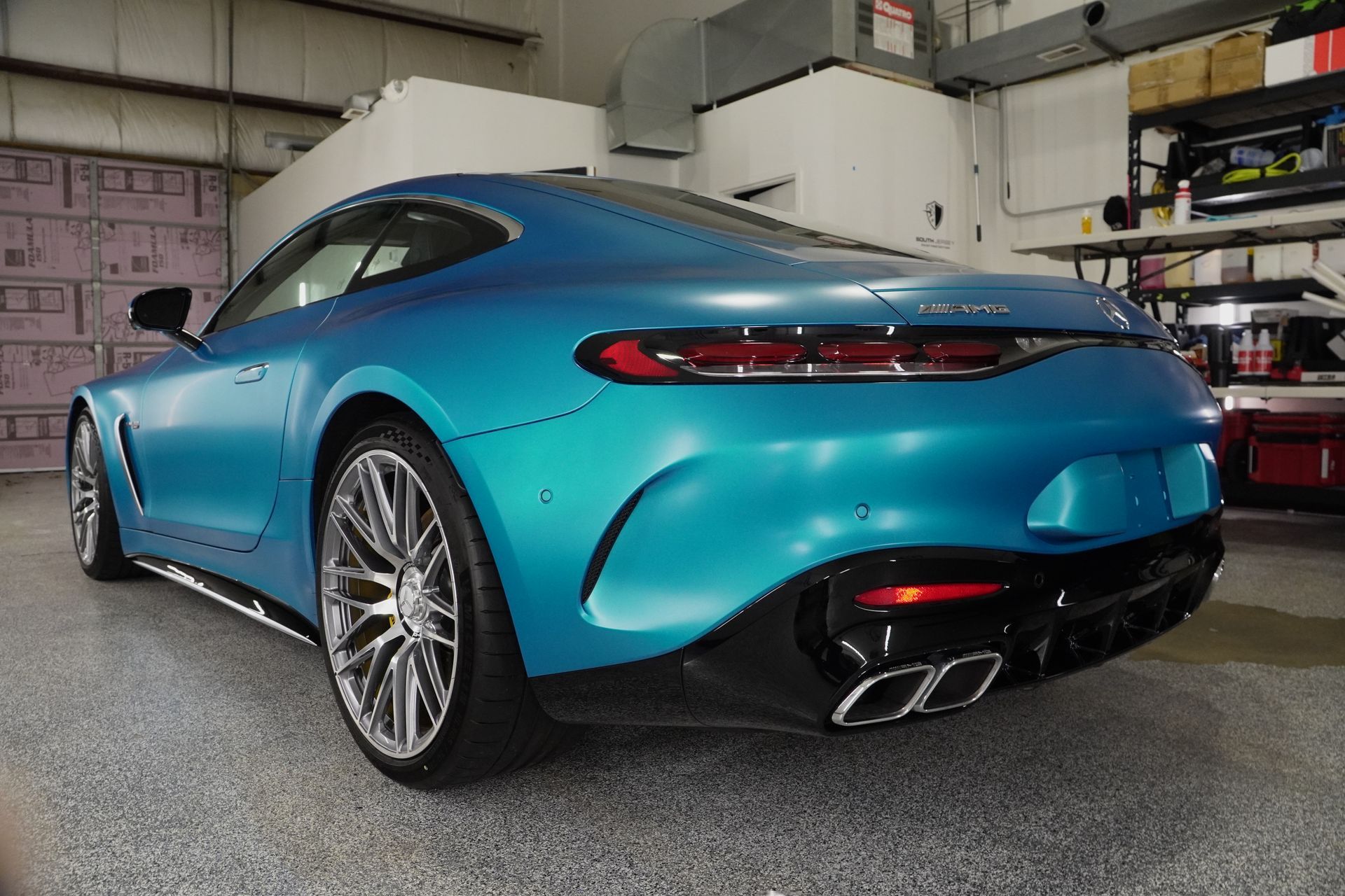 A blue sports car is parked in a garage.