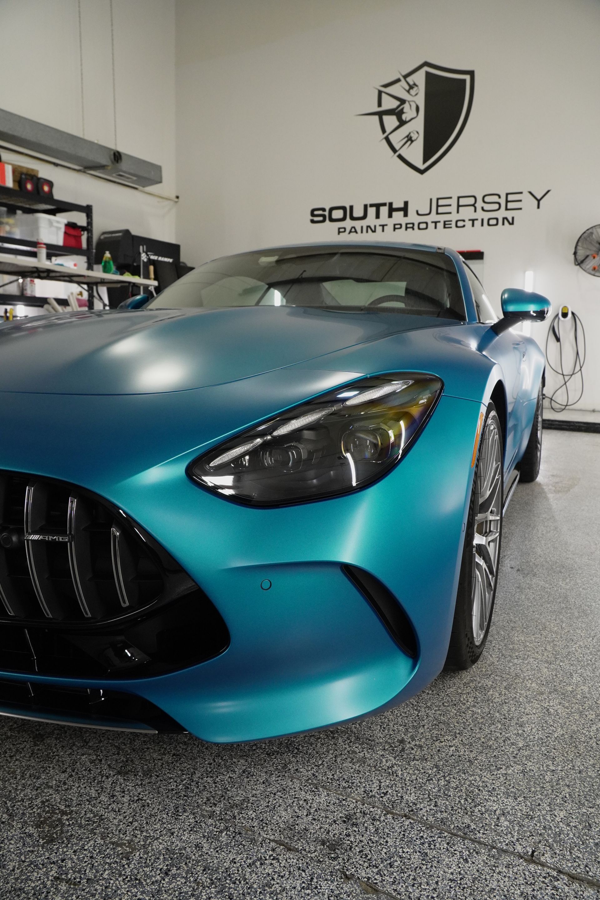 A blue sports car is parked in a garage.