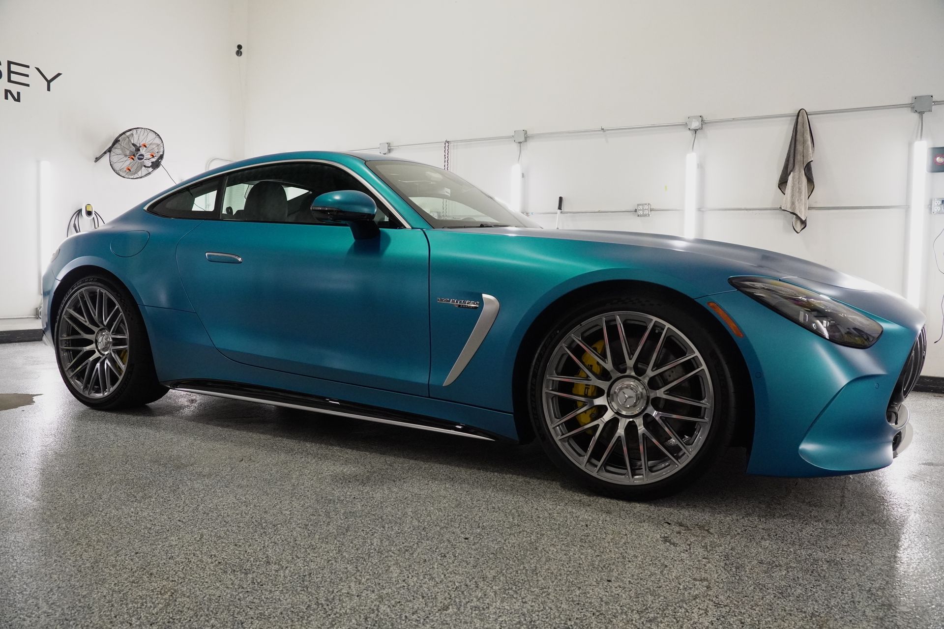 A blue sports car is parked in a garage.
