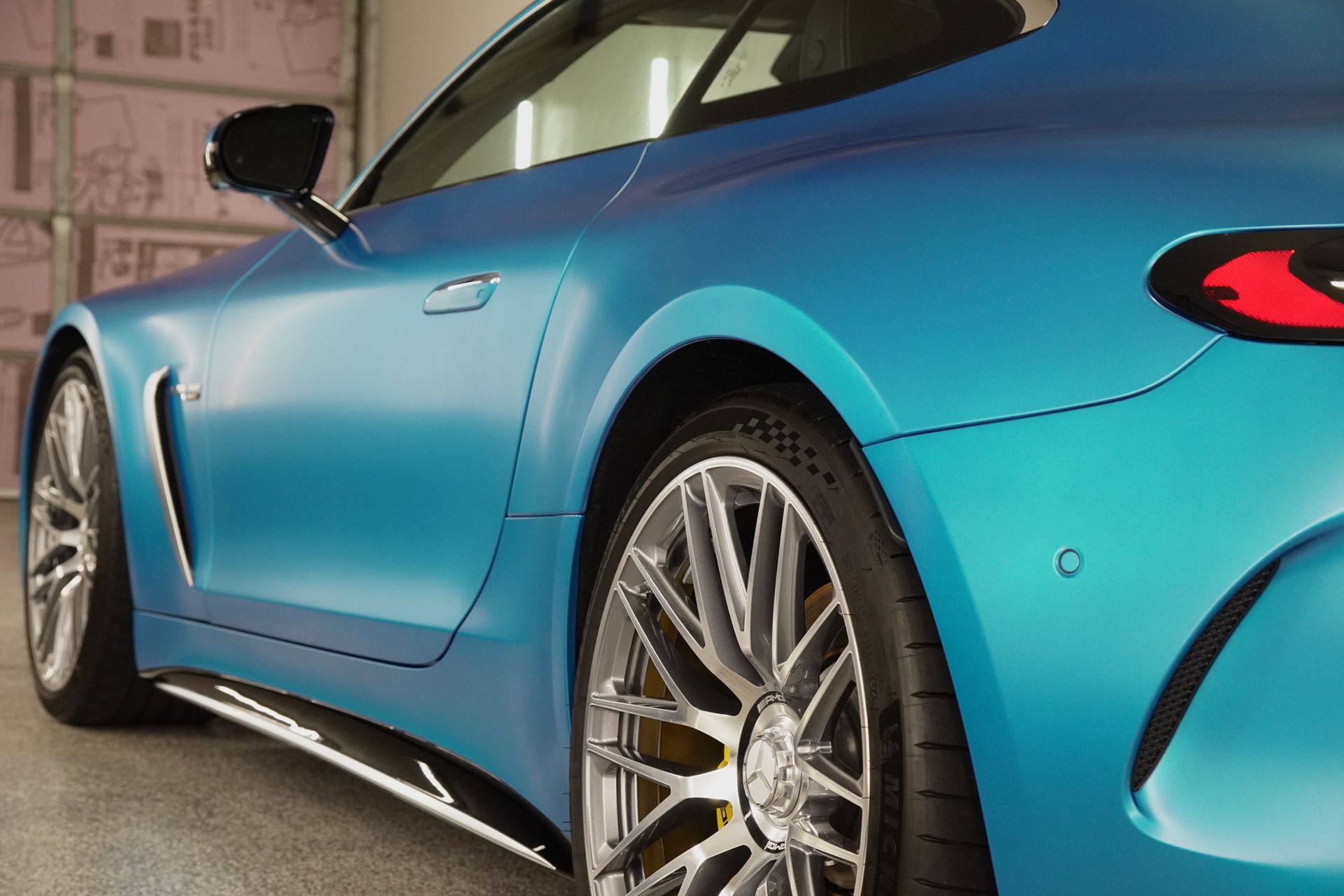 A blue sports car is parked in a garage.