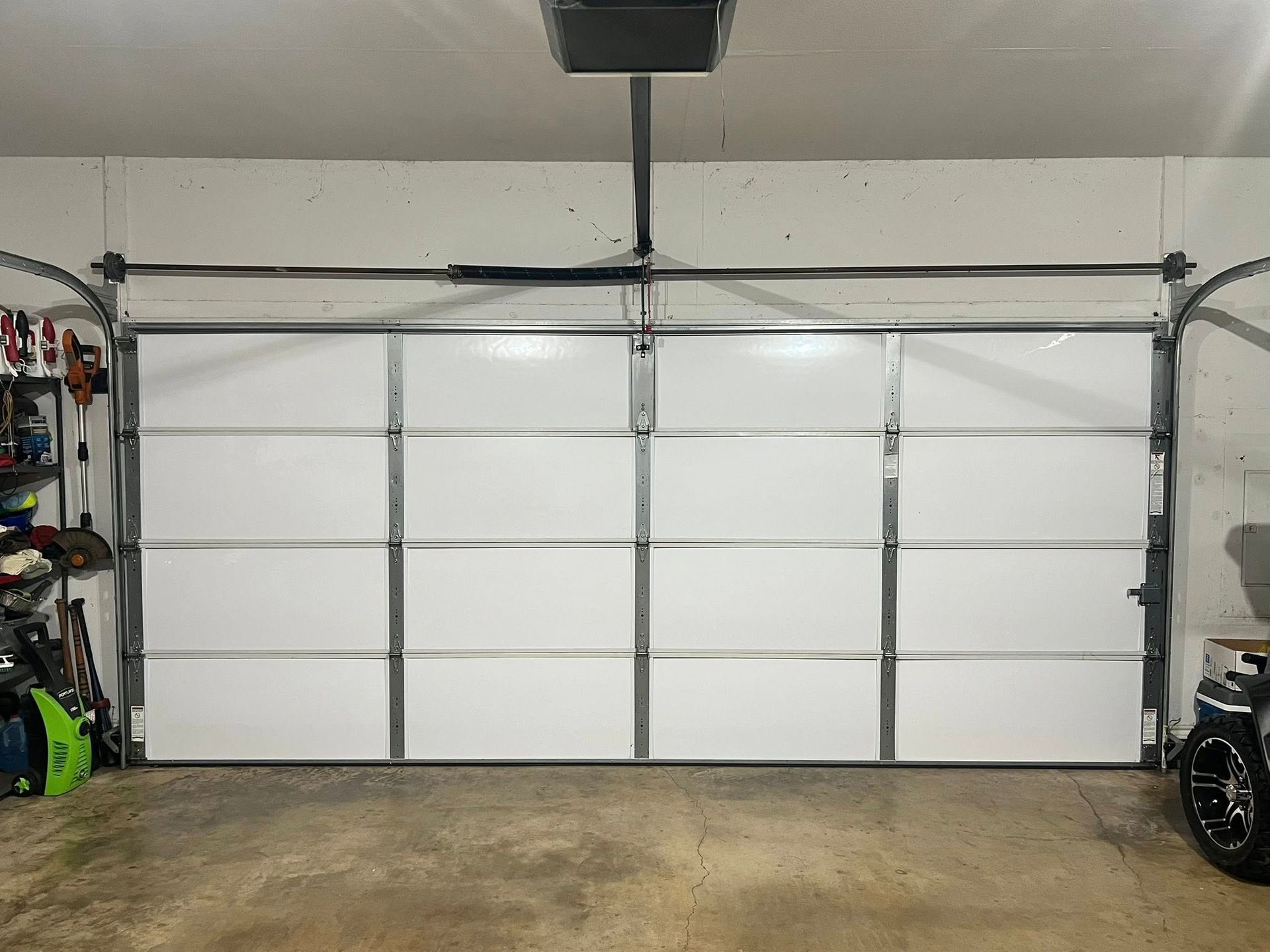 White garage door, closed, with metal framing, in a garage.