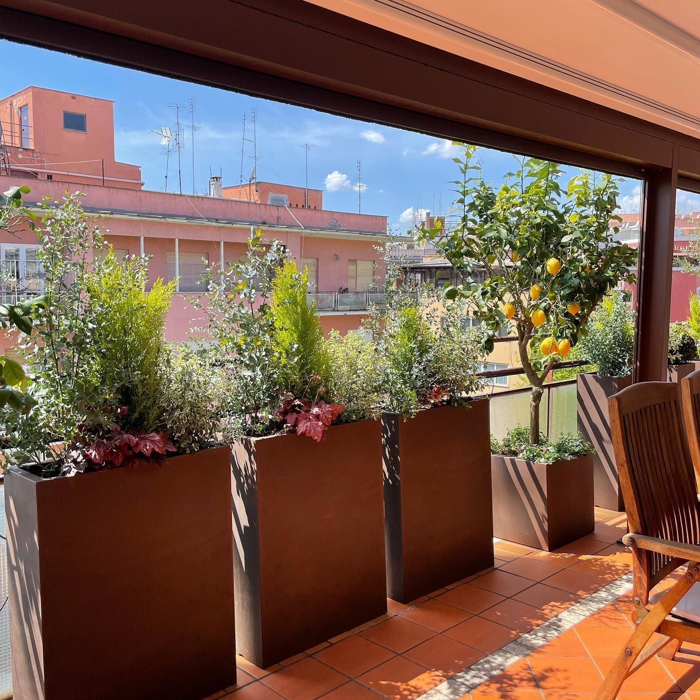 Un balcone con tante piante in vaso e sedie