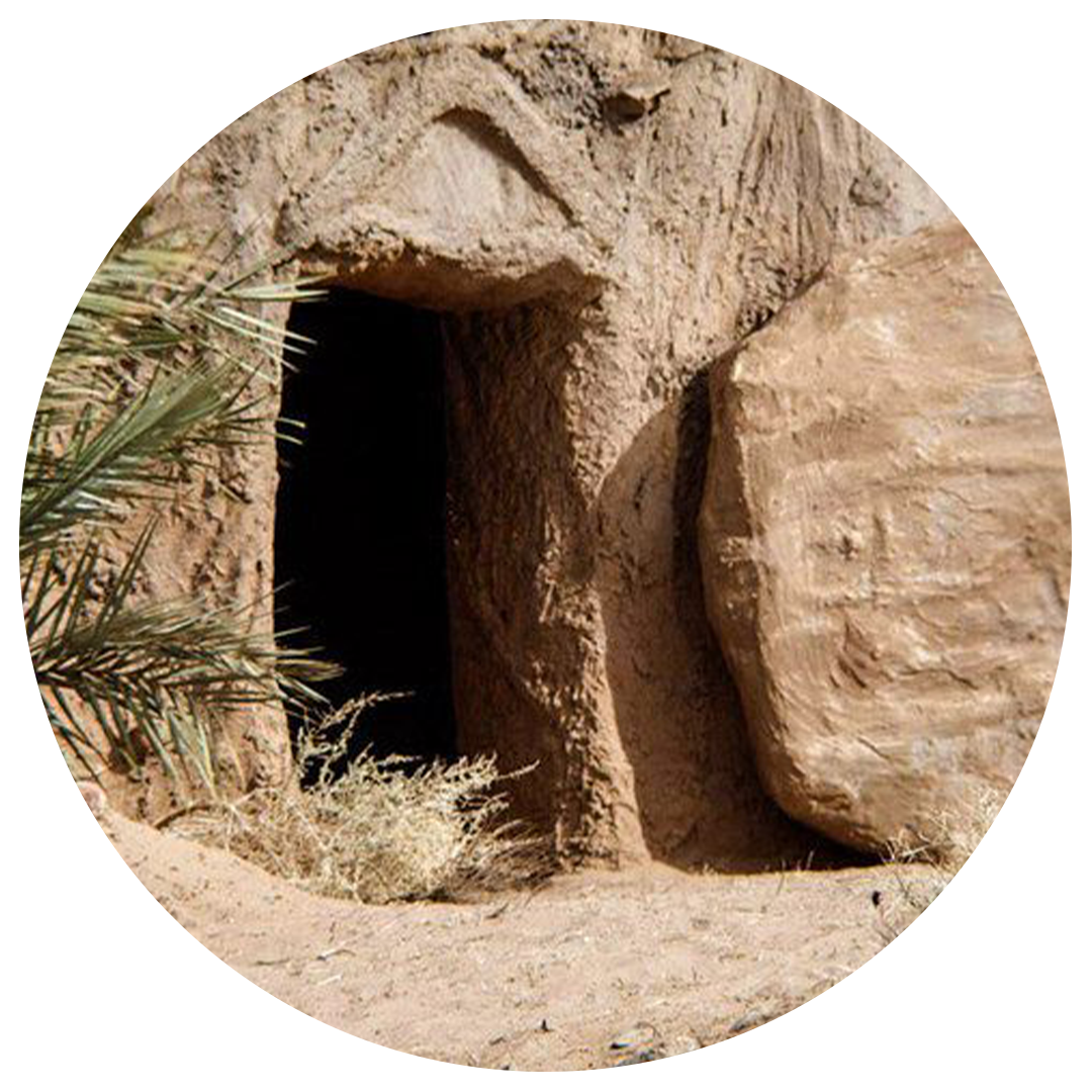 Tomb entrance with a large stone rolled away, arid setting.