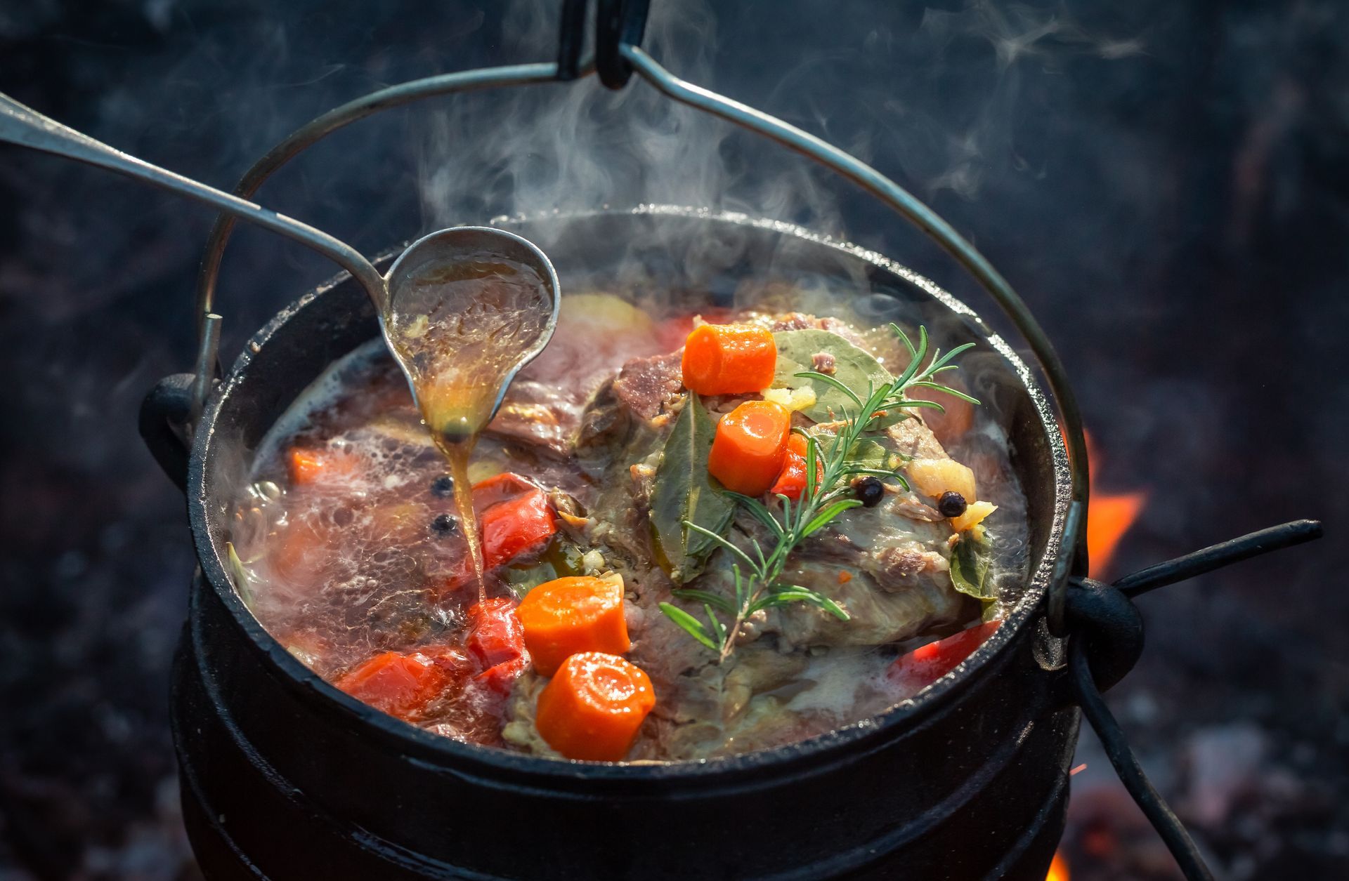 A pot of food is being cooked on a fire.