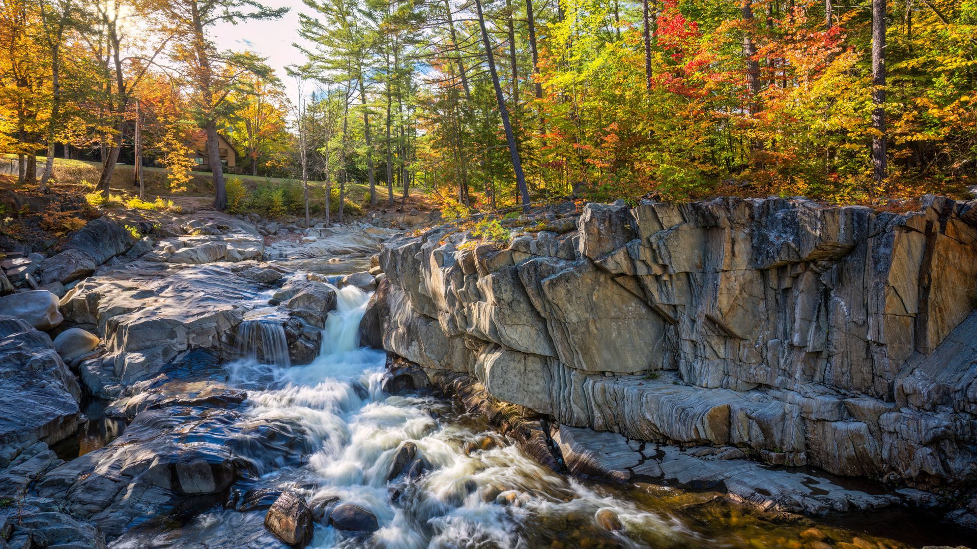 A waterfall is surrounded by rocks and trees at Coos Canyon, Maine.