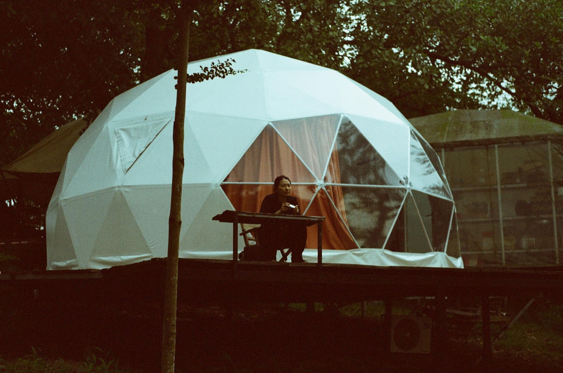 A man is playing a keyboard in front of a dome tent