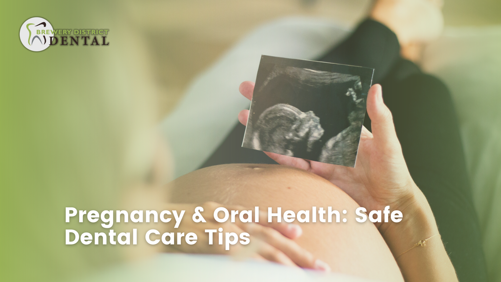 A pregnant woman is holding an ultrasound of her baby.