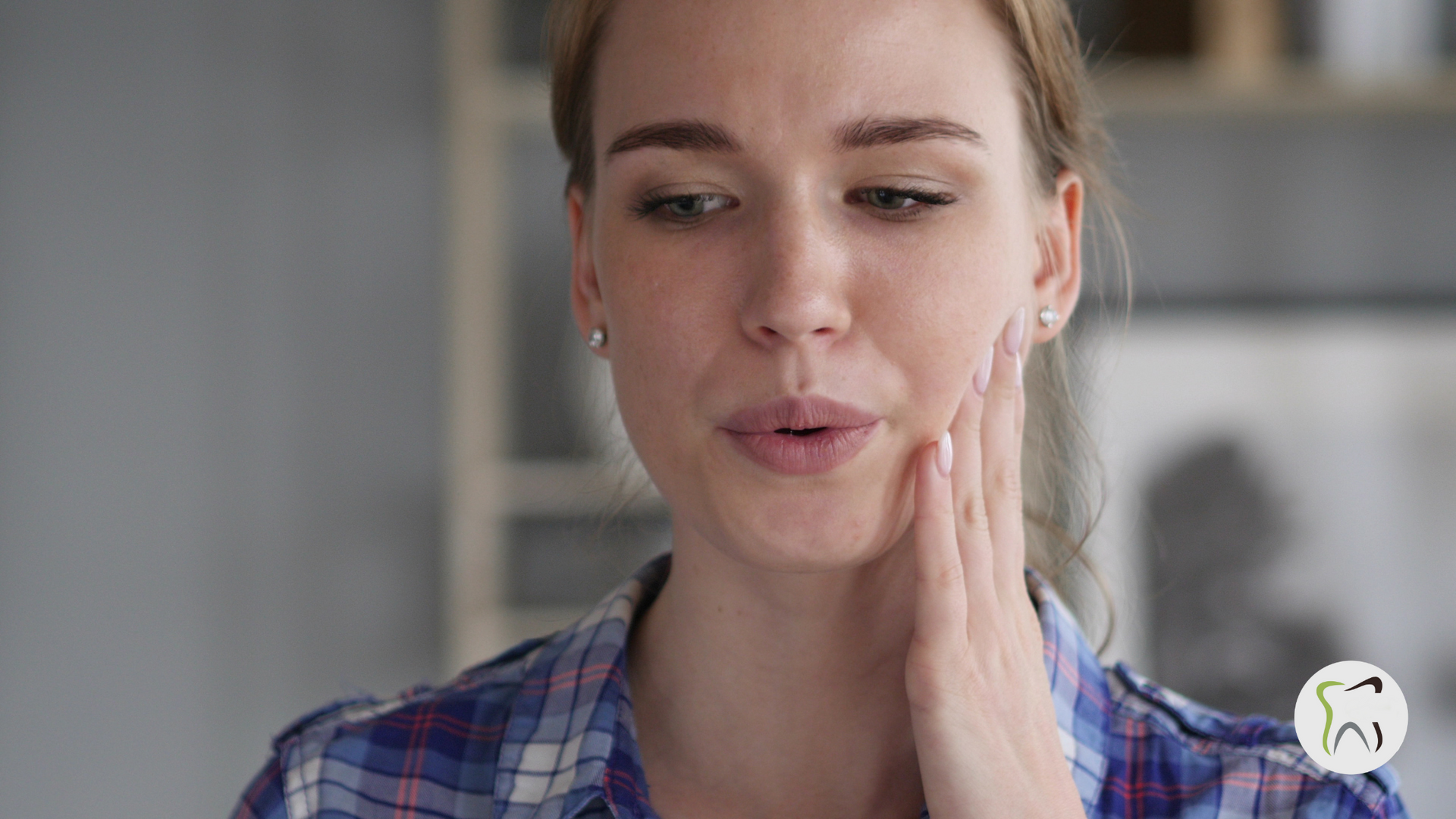 A woman is holding her face in pain because of a toothache.