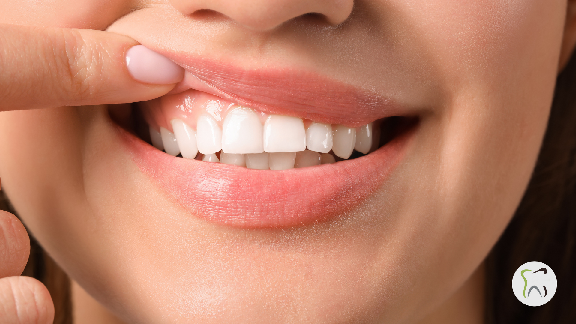 A woman is touching her teeth with her finger.