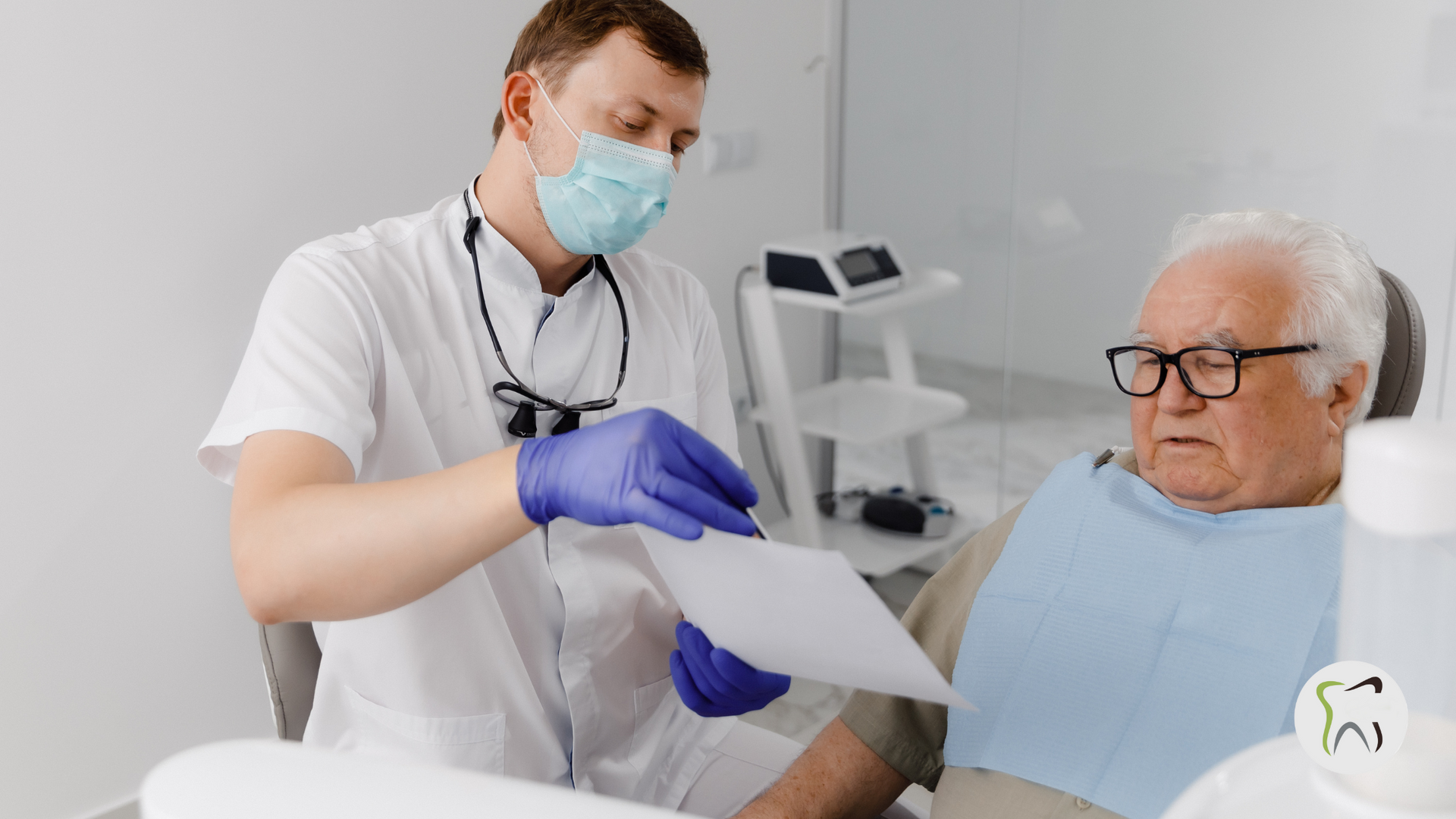 A dentist is talking to an elderly man in a dental chair.