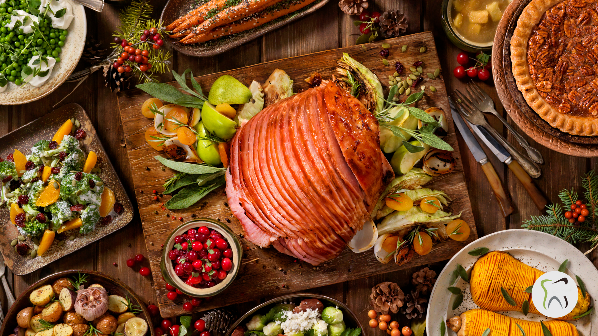 A wooden table topped with plates of food and a ham.