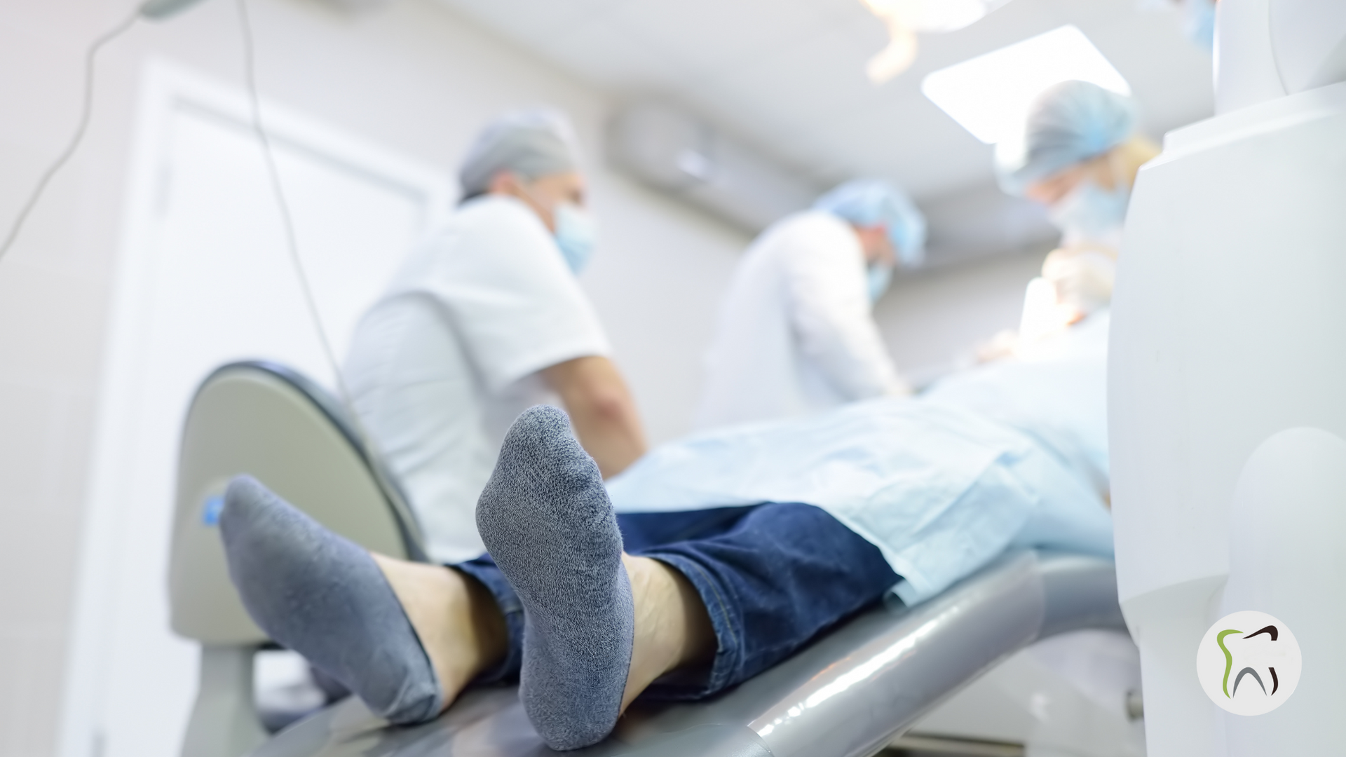 A person is laying in a dental chair with their feet up.