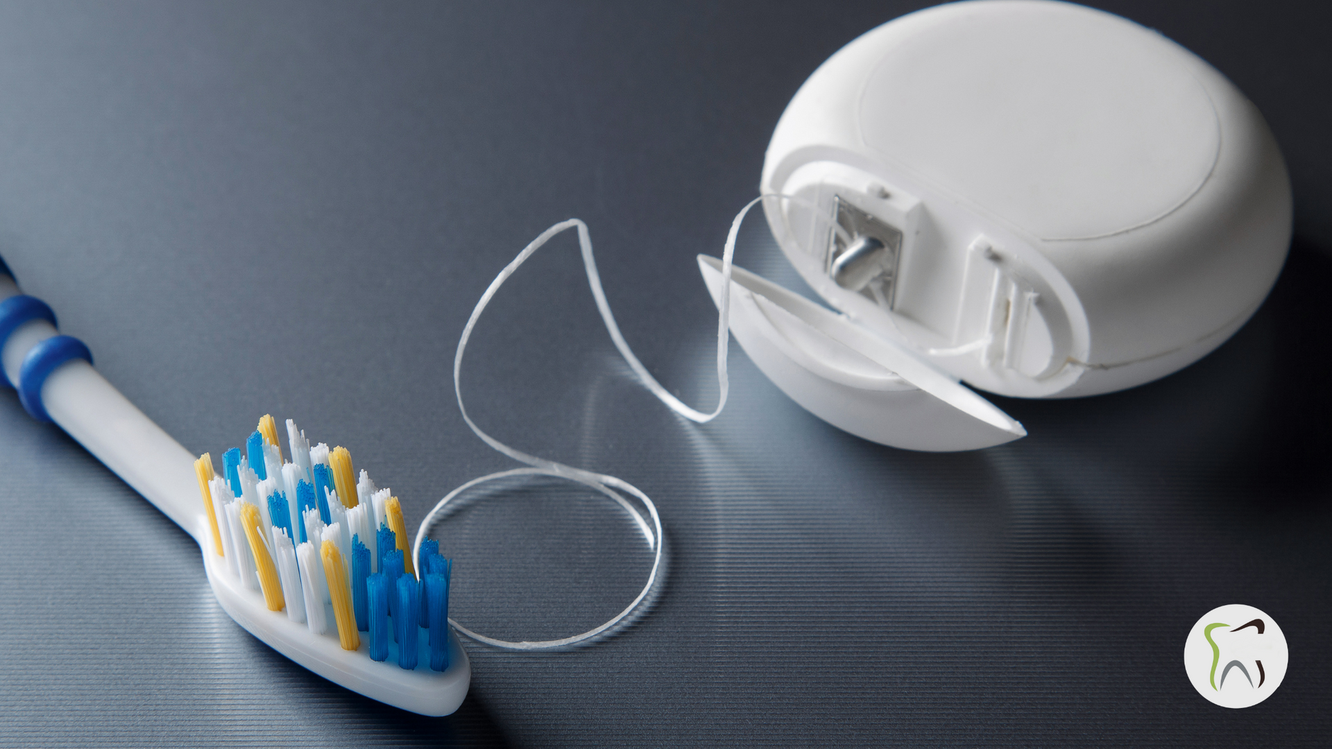 A toothbrush next to a roll of dental floss