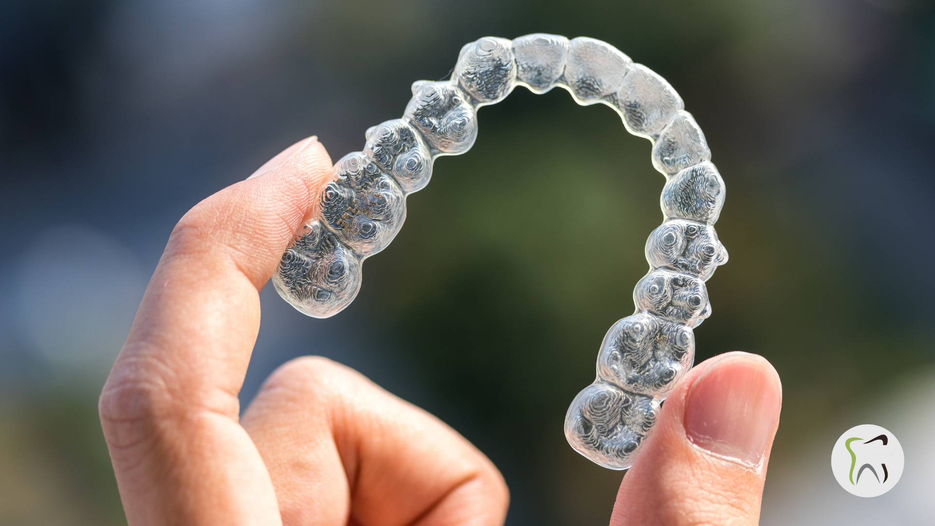 A person is holding a clear brace in their hand.