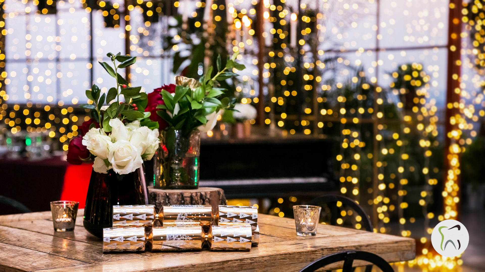 A wooden table with a vase of flowers and crackers on it.