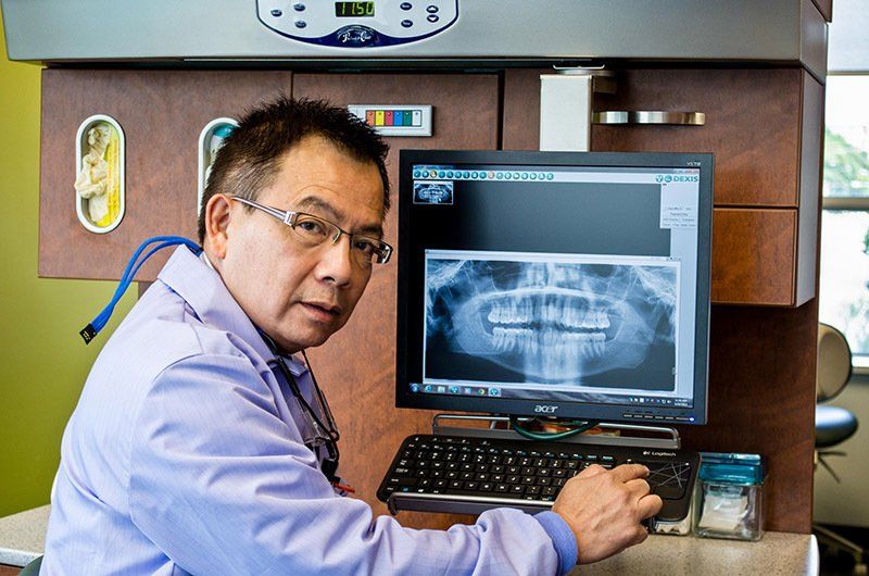 Dr. Francis Yeung | Dentist Beside A Digital X-Ray Of A Patient