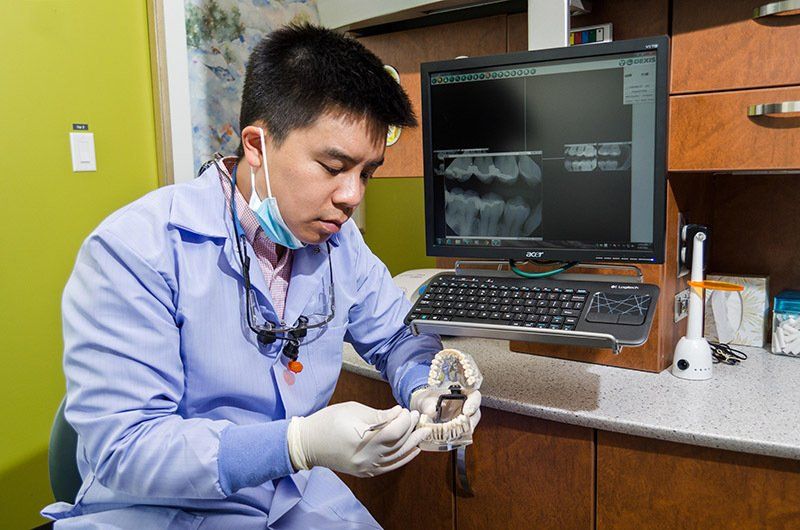 Dr. Jonathan Yeung  | Dentist Beside A Digital X-Ray Holding A Mold