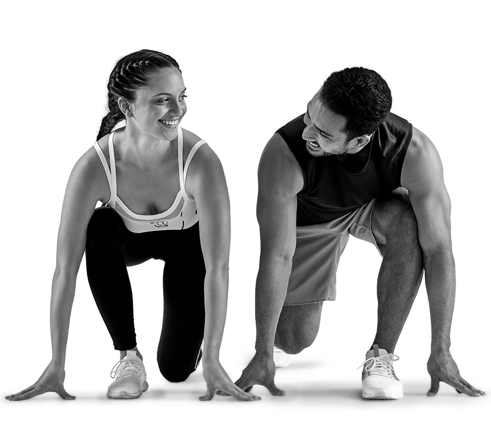 Woman and man, in athletic gear, crouched at a starting line, smiling at each other. Woman and man, in athletic gear, crouched at a starting line, smiling at each other.