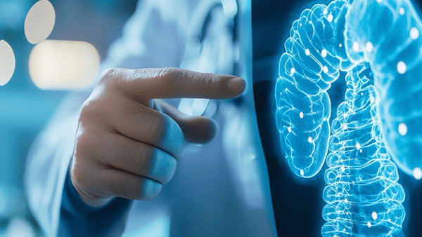 Doctor pointing to a glowing, digital, skeletal representation of a human. Blue tones.