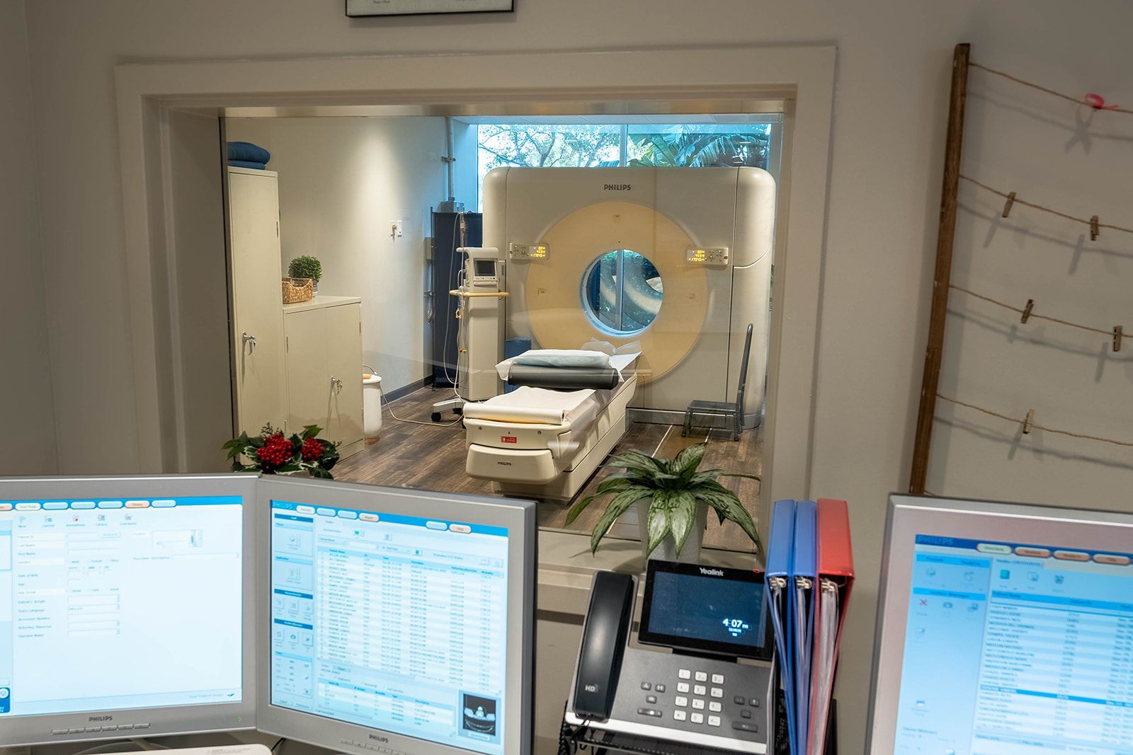 CT scanner room with computer monitors in foreground.