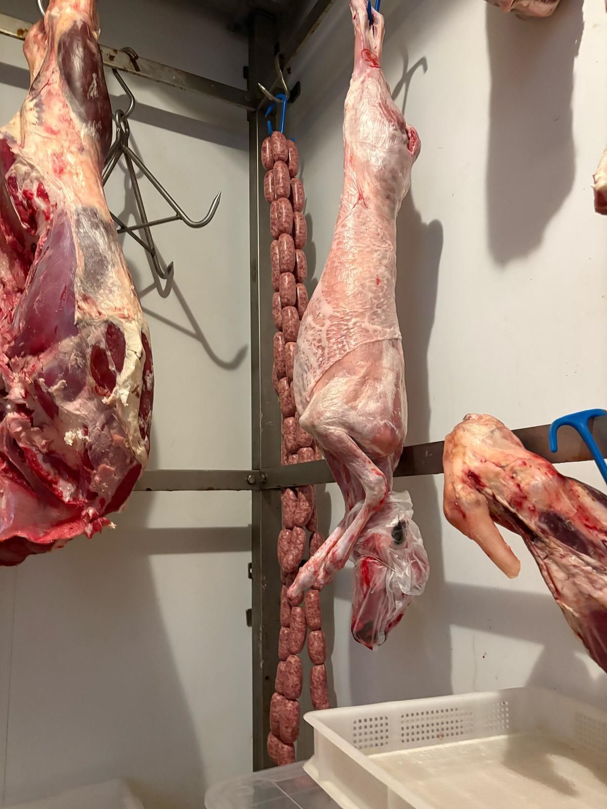Una persona sta tagliando un pezzo di carne in una macelleria