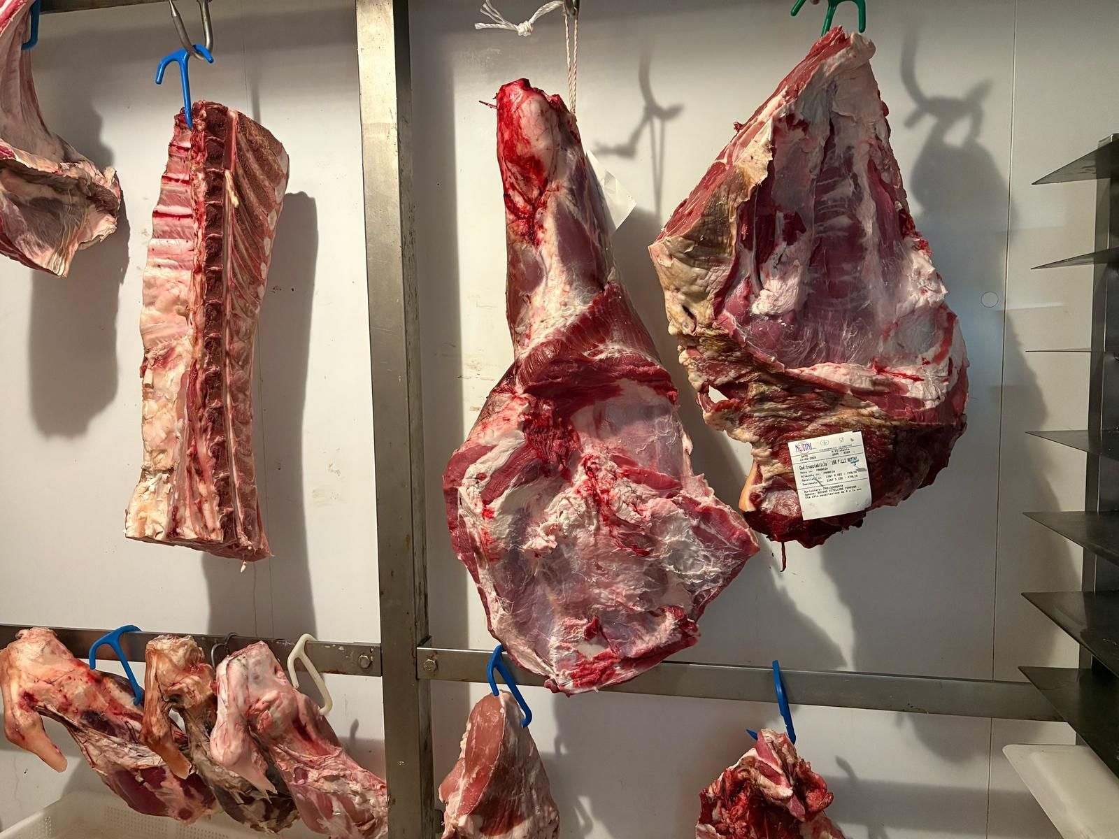 Un mucchio di carne appeso a una rastrelliera in una macelleria