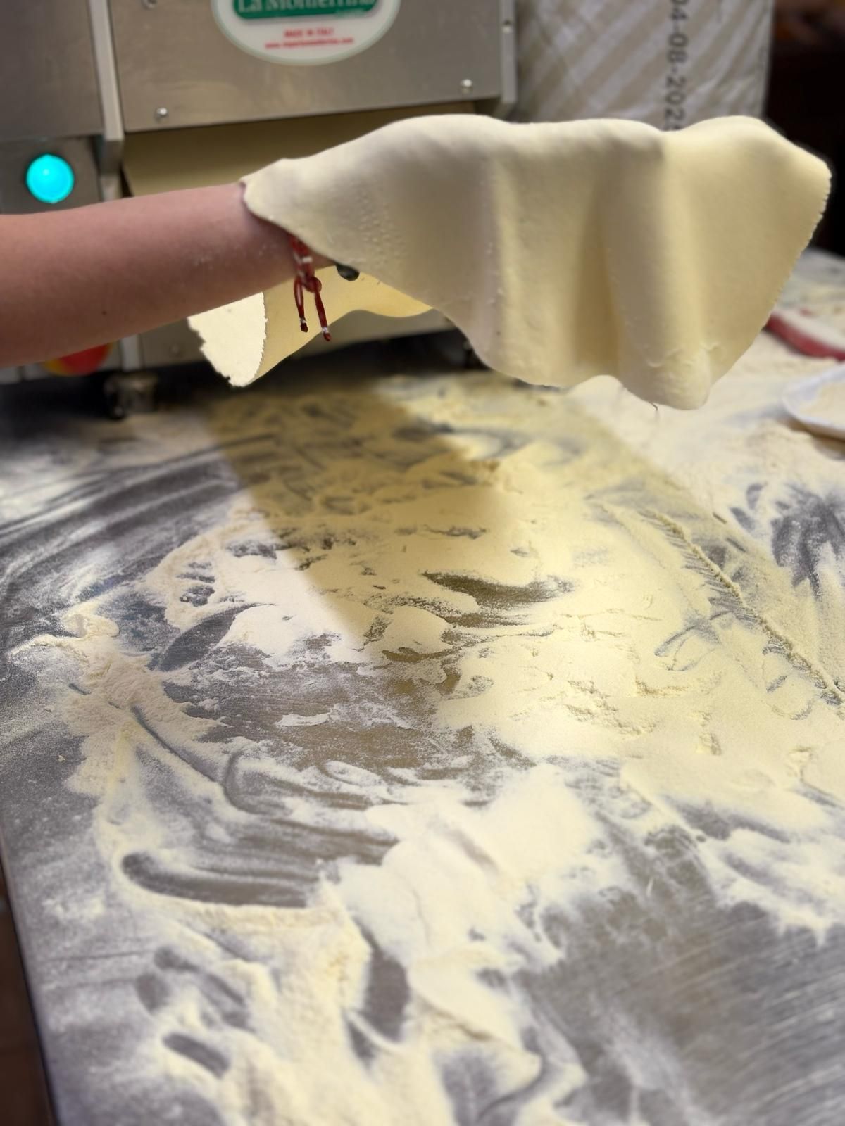 Una persona tiene in mano un pezzo di pasta