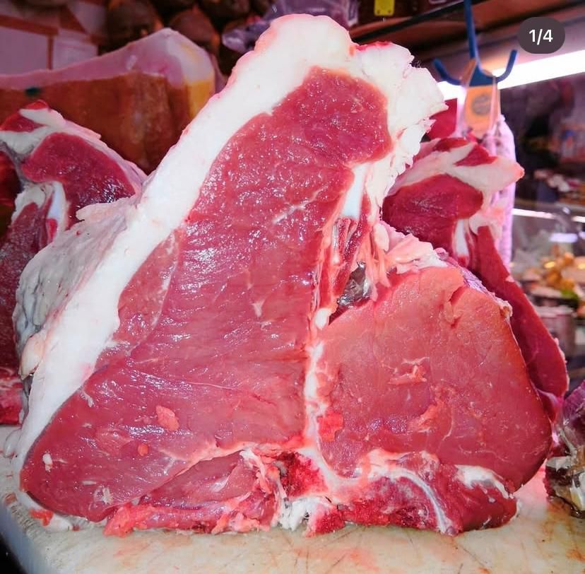 Un grosso pezzo di carne è appoggiato su un tagliere con il numero 1/4 nell'angolo