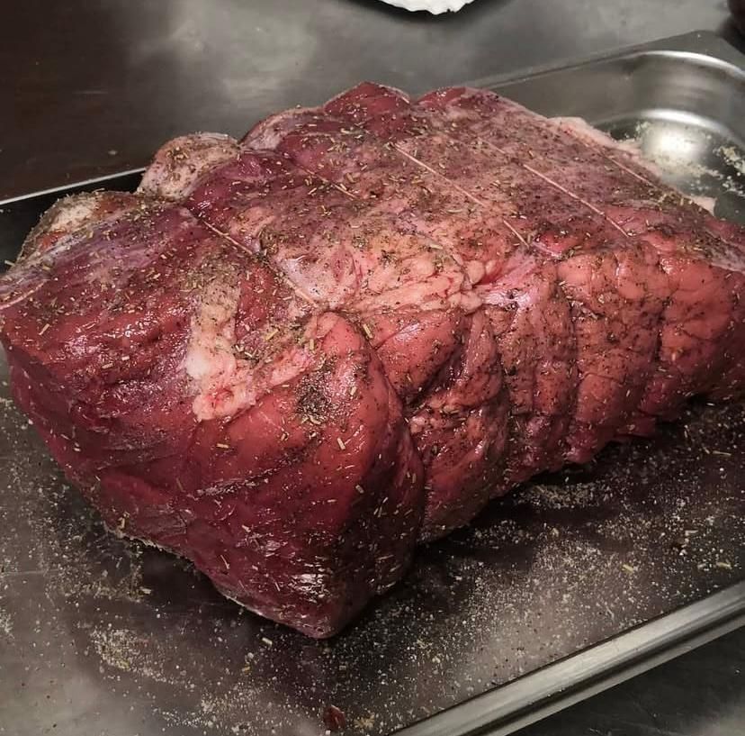 Un grosso pezzo di carne è appoggiato su un vassoio di metallo