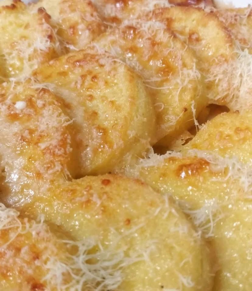 Un primo piano di un piatto di cibo con del formaggio sopra.