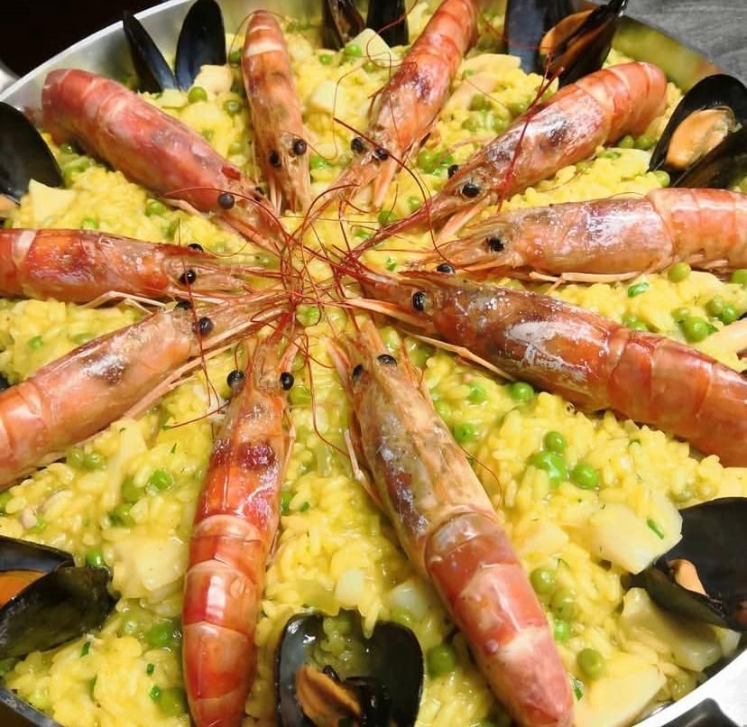 Un primo piano di una paella con gamberi e cozze