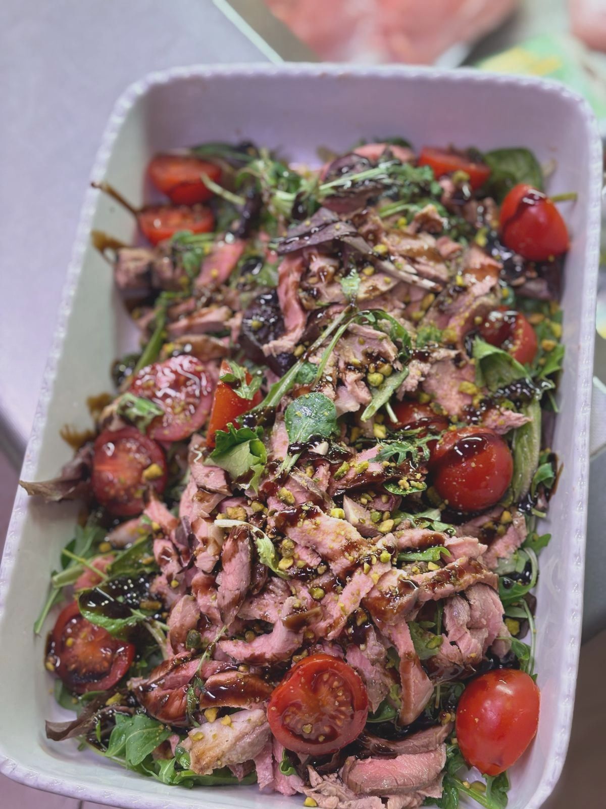 Una casseruola bianca riempita con un'insalata di carne e verdure.