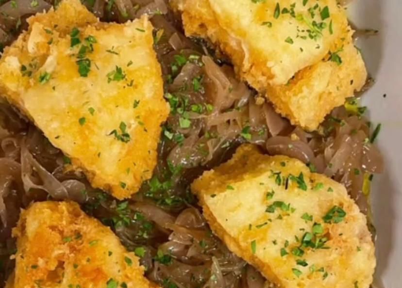 Un primo piano di un piatto di cibo con carne e verdure su un tavolo.