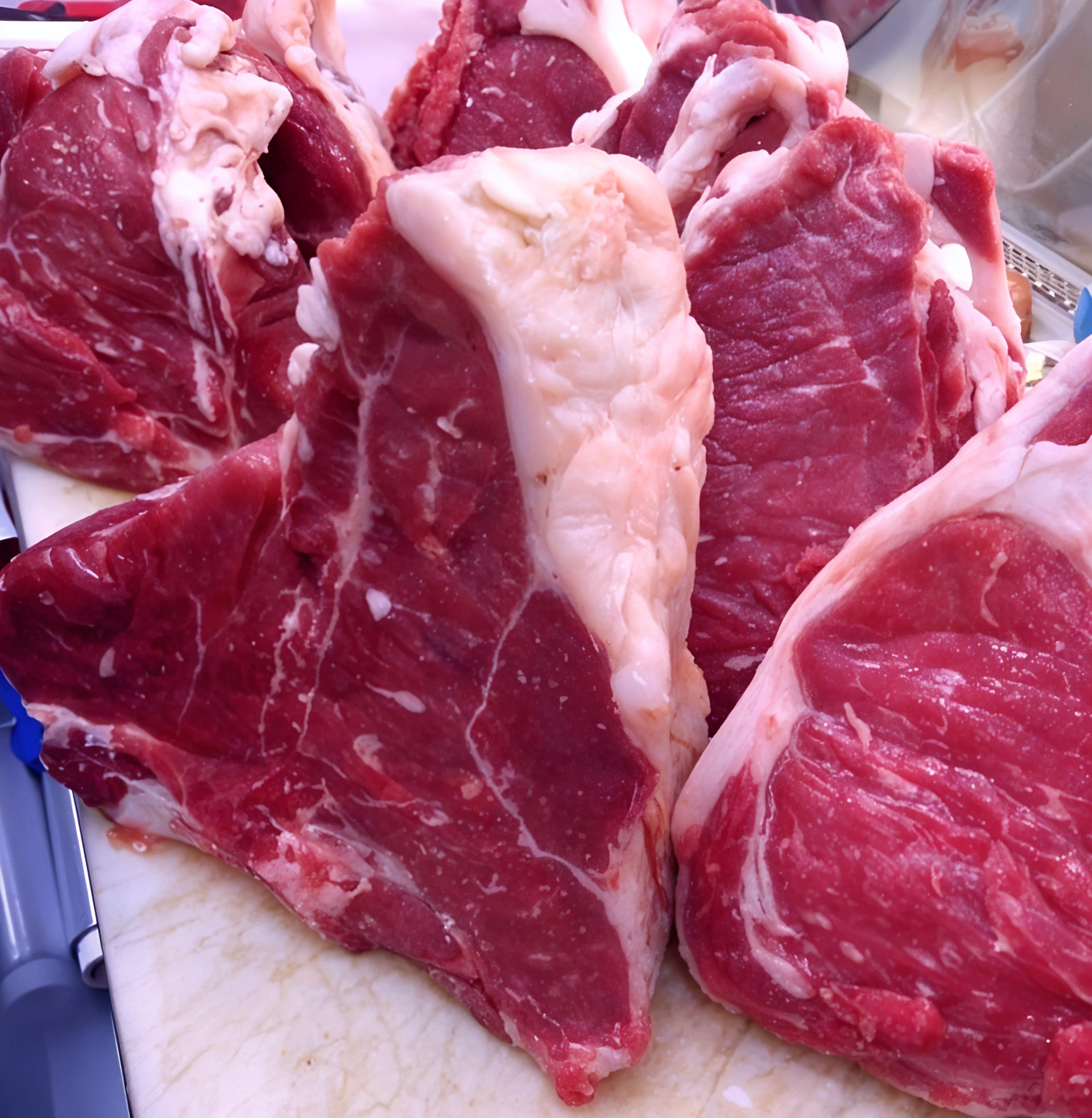 Una pila di bistecche di manzo crude su un tagliere