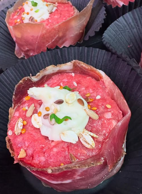 Un primo piano di un cupcake con carne e formaggio sopra