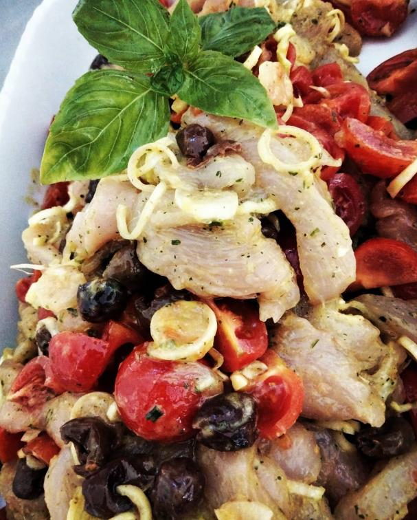 Un primo piano di un piatto di cibo con una foglia di basilico sopra