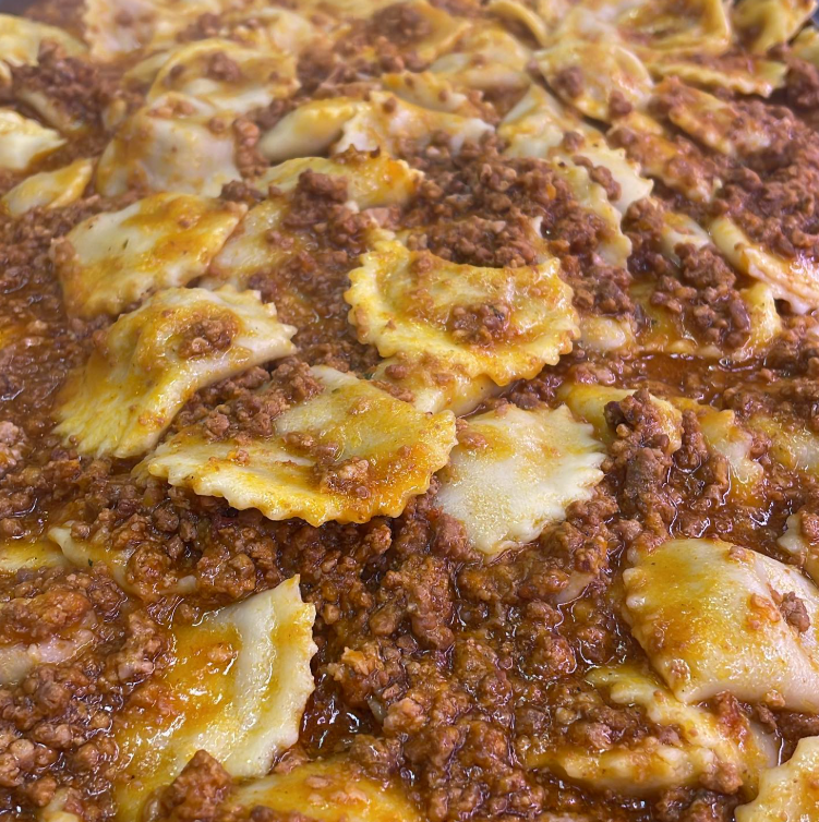 Un primo piano di un piatto di pasta con sugo di carne.