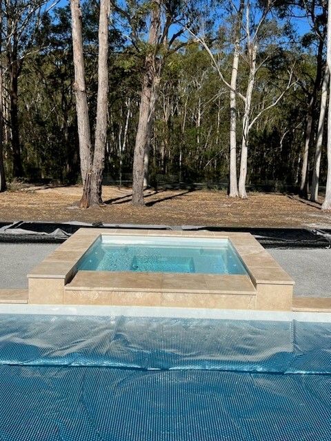 A Swimming Pool And Deck With Lounge Chairs - In Ground Pools in Nowra, NSW