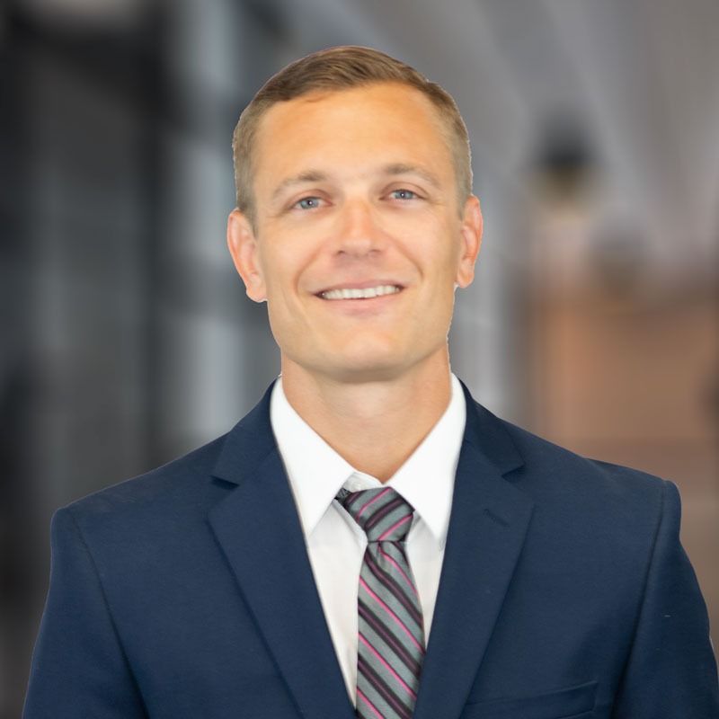 A man in a suit and tie is smiling for the camera.