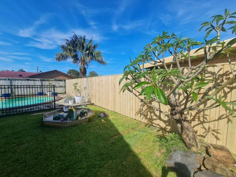 A Backyard with A Wooden Fence and A Pool — Quality Fencing Solutions in Ballina, NSW