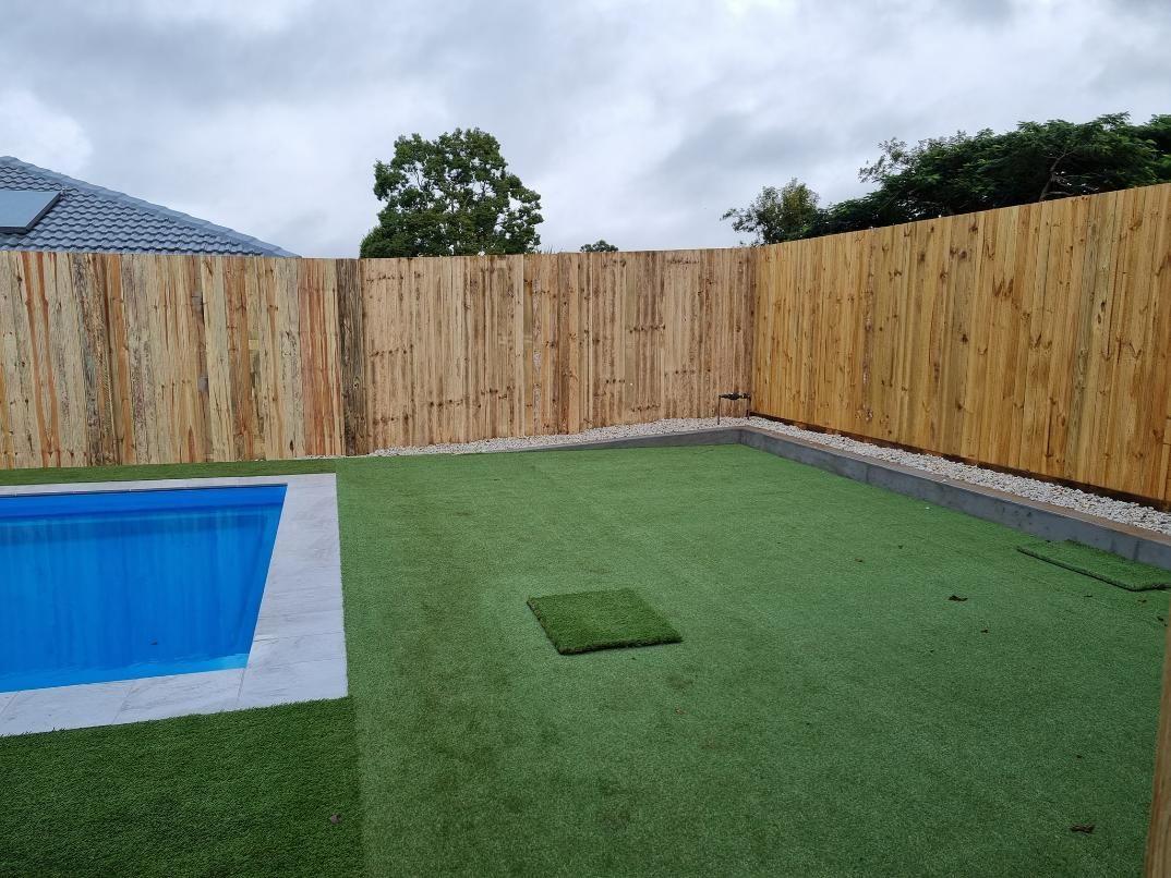 A Wooden Fence Surrounds a Swimming Pool in A Backyard — Quality Fencing Solutions in Ballina, NSW