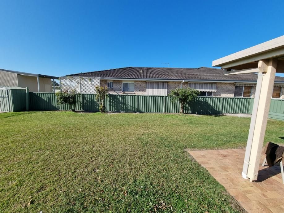 A Backyard with A Fence and A House in The Background — Quality Fencing Solutions in Ballina, NSW