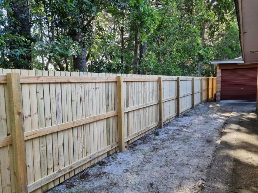A Wooden Fence Is Sitting Next to A Garage in Front of A House — Quality Fencing Solutions in Ballina, NSW