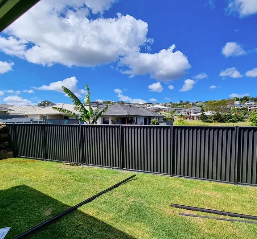 A Backyard with A Fence and A House in The Background — Quality Fencing Solutions in Ballina, NSW