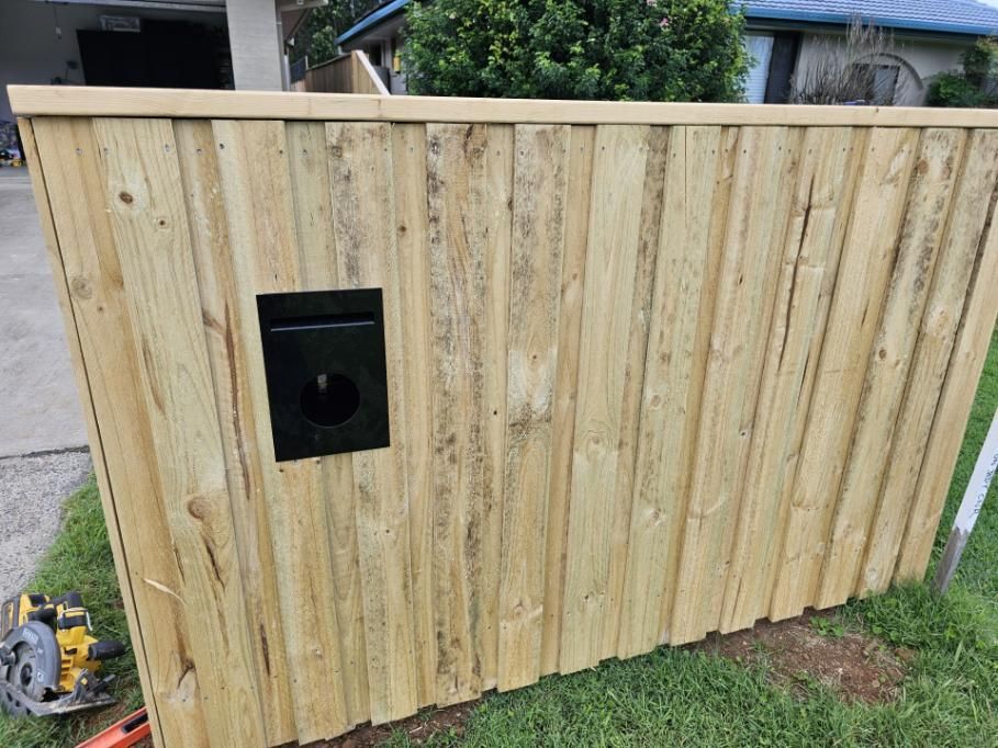 A Wooden Fence with A Mailbox in The Middle of It — Quality Fencing Solutions in Lennox Head, NSW