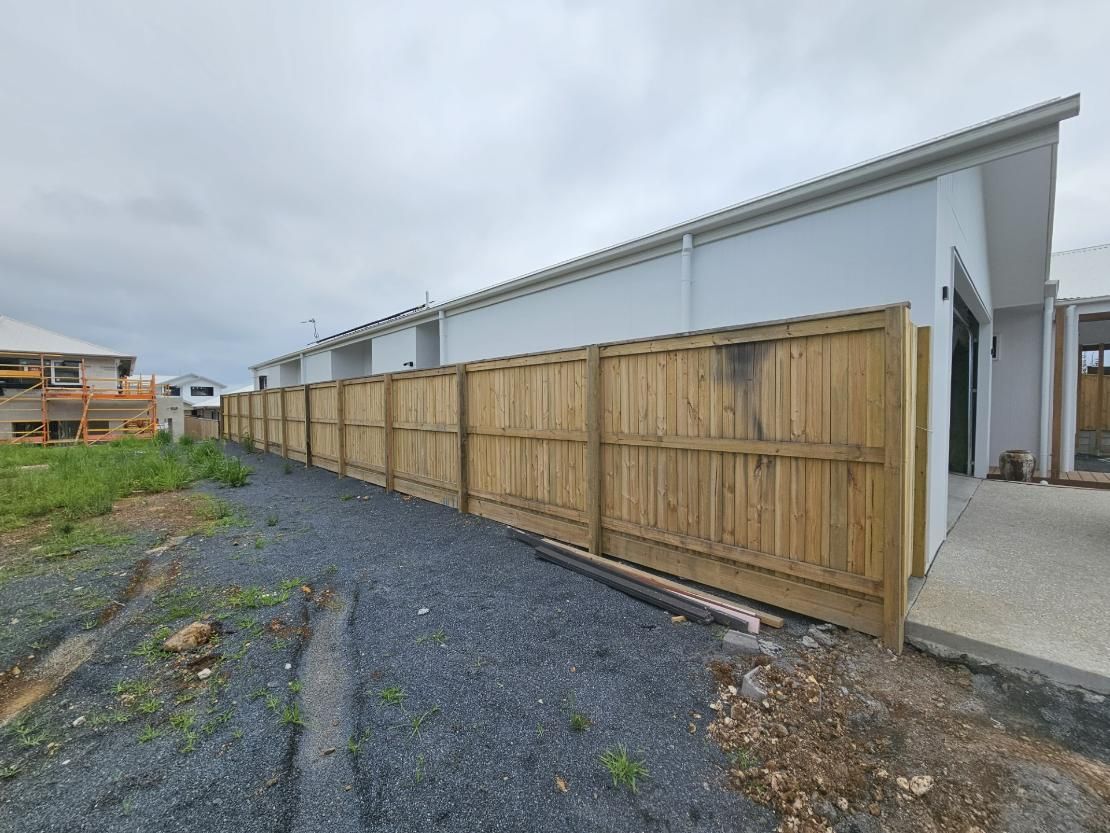 A Wooden Fence Is Surrounding a House Under Construction — Quality Fencing Solutions in Ballina, NSW