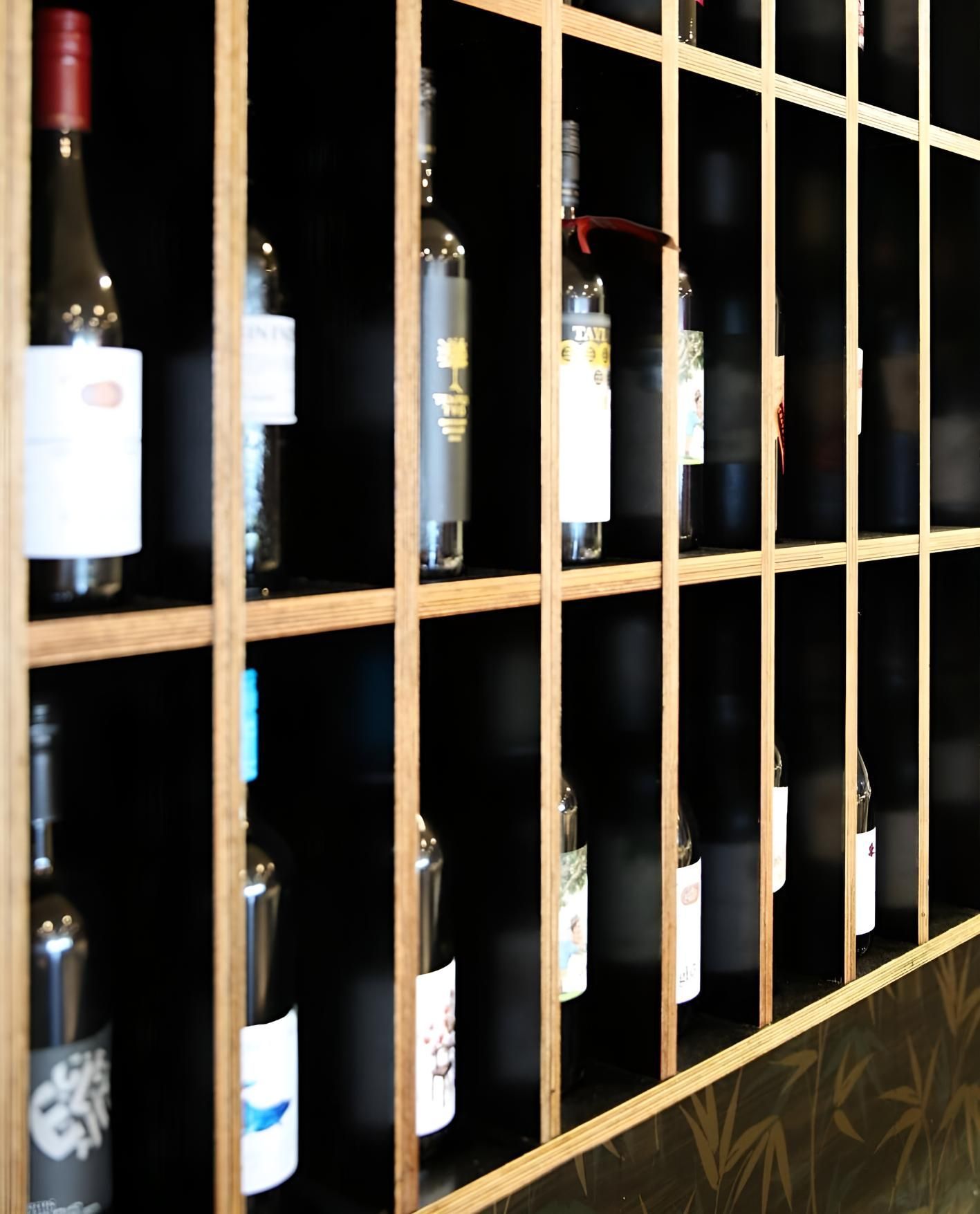 Several Bottles Of Wine Are Lined Up On A Wooden Shelf — Mod Thai Nelson Bay In Nelson Bay, NSW