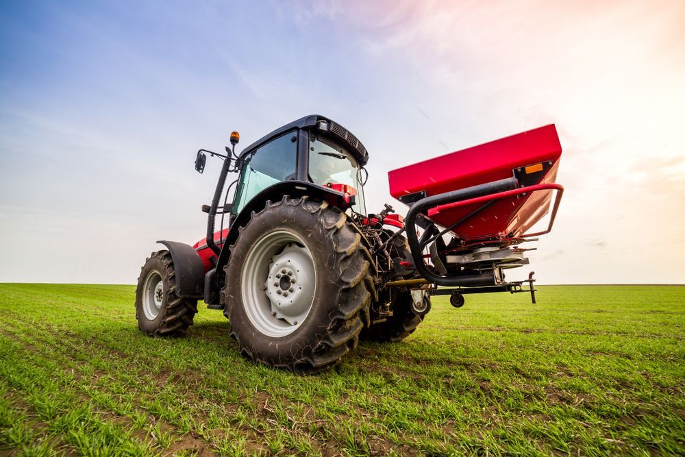 A Tractor is Spraying Fertilizer on a Lush Green Field — Ballina Bearing Supplies In Tweed Heads, NSW